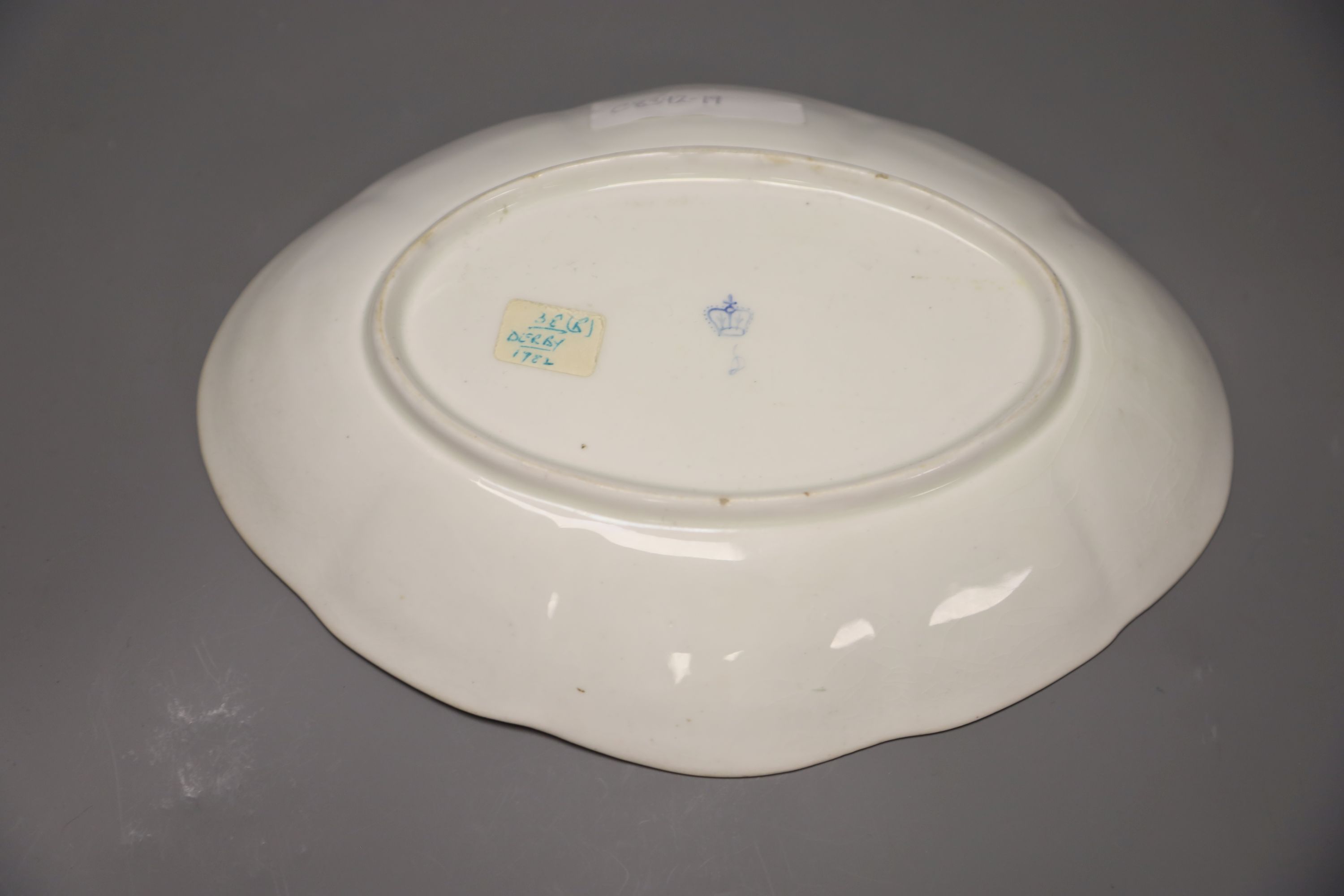 A Chelsea Derby oval dish painted with flowers in the manner of Withers under a Smiths blue and gilt border, blue crown D mark, length